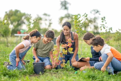 gardener plating a plant with kids