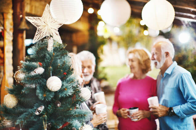 Senior citizens next to a Christmas tree